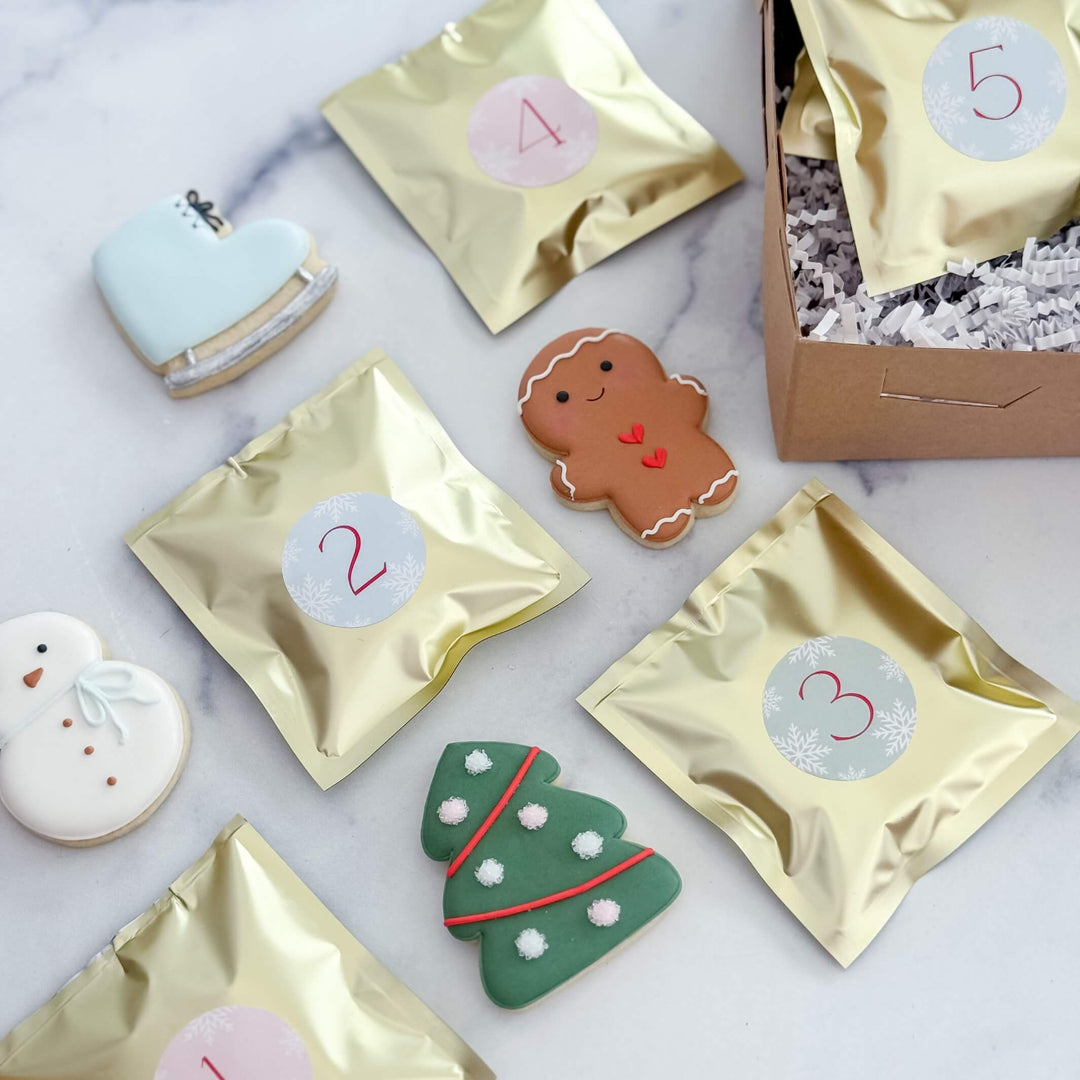 Decorative cookies with gold packaging and numbered labels on a marble surface