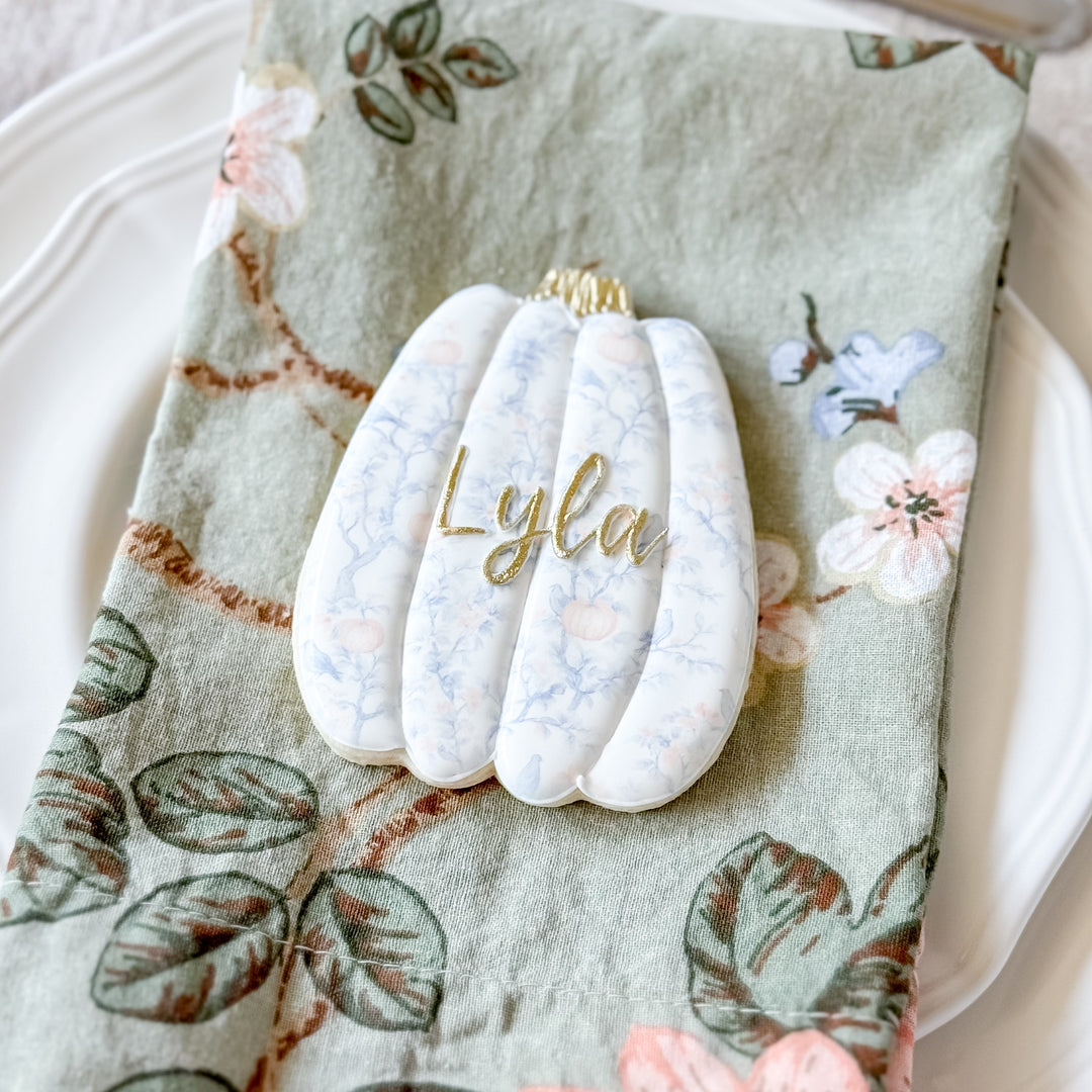 Set of decorated Thanksgiving pumpkin cookies with place cards from Southern Sugar Bakery, featuring festive orange and brown designs.