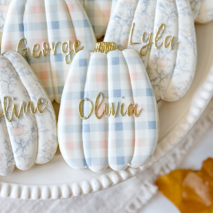 Thanksgiving pumpkin place card cookies from Southern Sugar Bakery decorated as festive holiday treats and table decor.